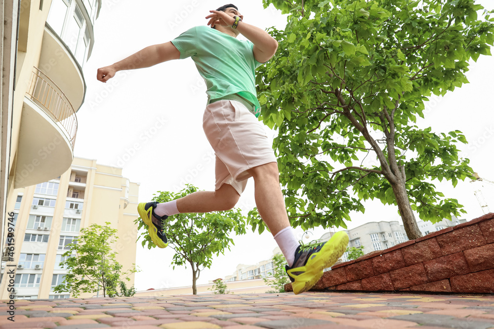 Muscular young man jumping outdoors