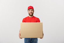Young Smiling Logistic Delivery Man In Red Uniform Holding The Box On White Background