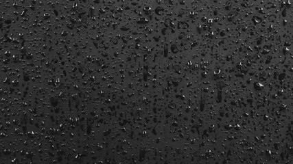 Aufkleber - Water droplets flowing on a black background.