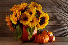 Autumn Flowers Composition In A Pumpkin Vase With Pumpkins On Wooden Background