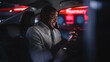 © Gorodenkoff - Happy Black Man in Glasses is Commuting Home in a Backseat of Taxi at Night. Handsome Male Using Smartphone and Smiling while in a Car in Urban City Street with Working Neon Signs.