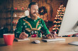 © deagreez - Photo of positive bearded man sit desk work pc take notes wear ugly pullover decorated office indoors