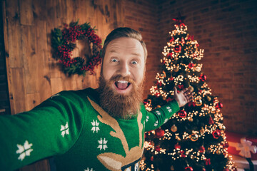 Wall Mural - Photo of amazed hospitable blogger guy shoot selfie invite x-mas party wear deer sweater decorated office indoors