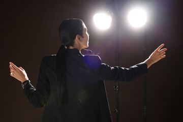 Wall Mural - Motivational speaker with headset performing on stage, back view