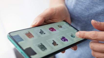 Wall Mural - Online shopping using a smartphone. E-commerce. Close-up of hands on the screen of a mobile phone when choosing a product.