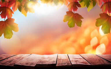 Wall Mural - A wood table, tabletop product display with a golden autumn sunset sky and leaves background for seasonal, autumnal thanksgiving images.