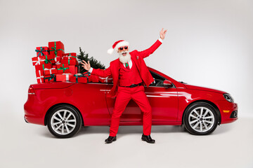 Poster - Full length body size view of attractive cheerful Santa dancing near car december season isolated over grey color background