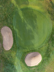 Canvas Print - Drone photography of golf cart with putting green and bunkers.