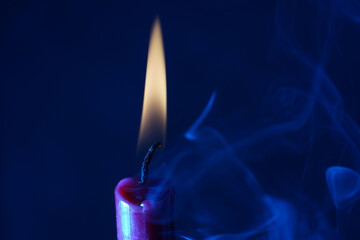 Poster - Burning candle against a blue background