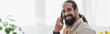 © LIGHTFIELD STUDIOS - bearded latin man talking on mobile phone and smiling at camera at home, banner