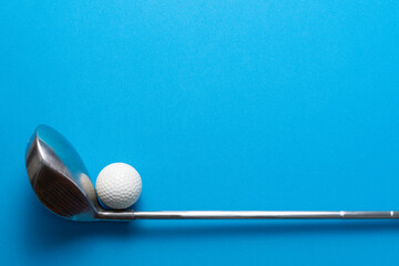 Wall Mural - golf ball and golf club on blue background, sport concept