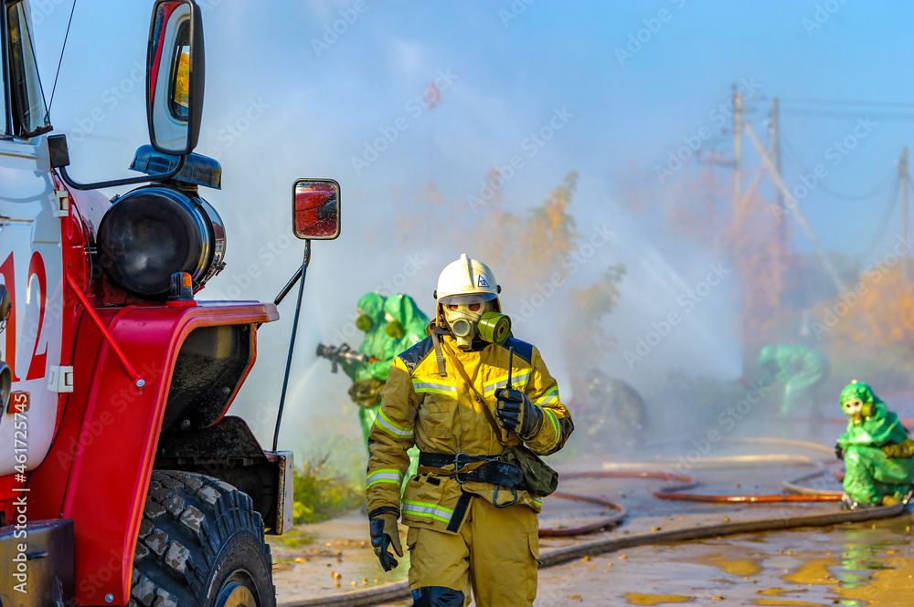 Rescuers in chemical protection suits eliminate an ammonia leak and ...