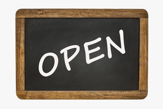 Open, written on a black chalk board with a wooden frame