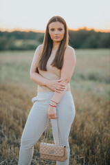 Poster - Vertical shot of a young Caucasian female model posing in a wheat field