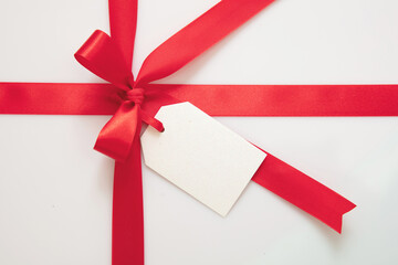 Wall Mural - gift card blank and red ribbon bow on white background, christmas, valentine present concept
