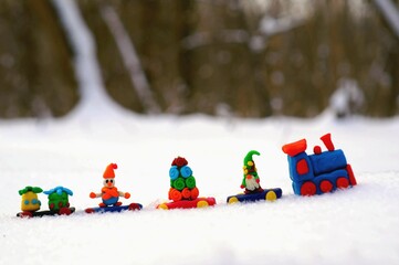 Wall Mural - Christmas train made of plasticine in the forest on the background of snow.