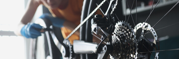 Wall Mural - Woman repairman in rubber gloves repairing bike with tools closeup