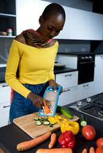 Young African American Woman Wearing A Yellow Shirt Grating Carrots