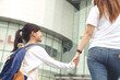 © FAMILY STOCK - Back to school. Asian mother and daughter pupil girl with backpack holding hand and going to school together. Beginning of lessons. First day