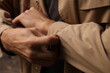 © Катя Богачук - hands of a man a man's hands buttoning the cufflinks on his coatbusinessmenbeautiful male hands in a brown coat