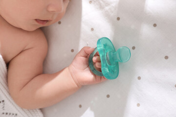 Sticker - Little baby with pacifier in bed, closeup