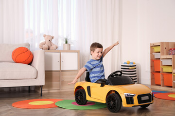 Poster - Little child playing with toy car in room