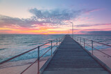 Fototapeta Zachód słońca - Port Noarlunga jetty with people during pink sunset, South Australia