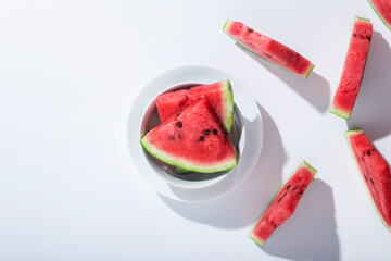 Sticker - Slices of ripe watermelon on a plate on a white table. Top view, flat lay