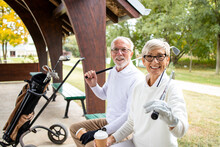 Portrait Of Senior People In Retirement Holding Golf Clubs And Ready For Golf Training.