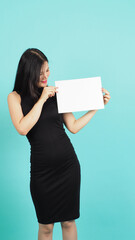 Wall Mural - Blank empty paper in teenage girl or woman's hand on green or Tiffany Blue background.she wear black dress