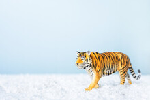 Tiger Symbol Of The Chinese New Year 2022. Figurine Of Tiger In Snow On Blue Background. Christmas Greeting Card. Banner, Copy Space.