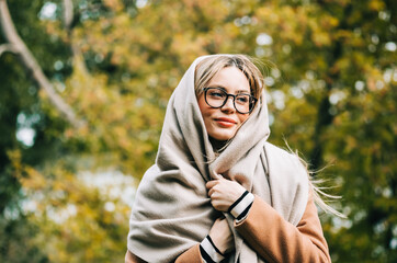 Wall Mural - Portrait of beautiful young woman in eyeglasses, enjoying autumn weather in the park. Woman walking in the autumn park.