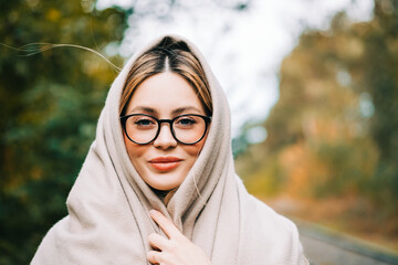 Wall Mural - Portrait of beautiful young woman in eyeglasses, enjoying autumn weather in the park. Woman walking in the autumn park.