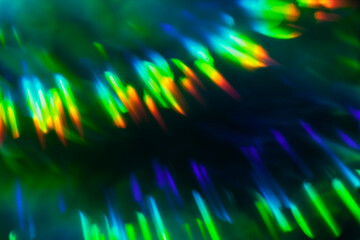 Abstract shiny foil glitter holographic out of focus rainbow gradient bokeh glowing background, texture effects created with camera