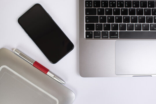 Laptop, smartphone and graphics tablet on a white table. office. top view. retoucher or graphic designer concept