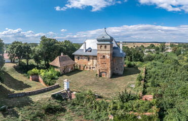 Wall Mural - Aerial view of medieval fortified castle Erdody manor house in Janoshaza, Vas county Hungary with restored onion shape roof and blue sky, surrounded by a dry moat