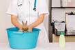 A ibhinqa veterinarian washes a rabbit ukusuka fleas kwi-blue basin. Ingcamango ka-petr lezempilo zonyango amaziko. Zokuthintela okanye unyango ka-hare izidleleleli.