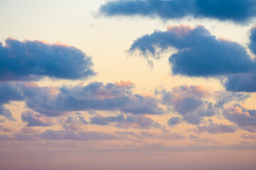 Wall Mural - Natural background, stunning view of some fluffy clouds on a purple and orange sky during a beautiful sunrise. Sardinia, Italy.
