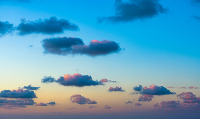 Wall Mural - Natural background, stunning view of some fluffy clouds on a purple and orange sky during a beautiful sunrise. Sardinia, Italy.