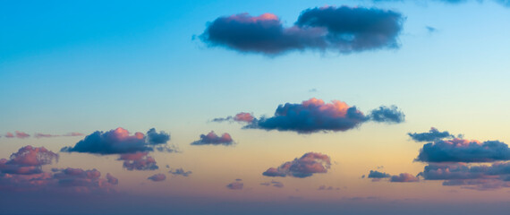 Wall Mural - Natural background, stunning view of some fluffy clouds on a purple and orange sky during a beautiful sunrise. Sardinia, Italy.