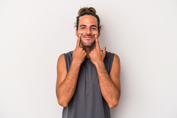 Young caucasian man isolated on gray background doubting between two options.