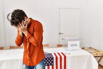 Sticker - Hispanic man standing by election room with sad expression covering face with hands while crying. depression concept.