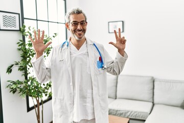 Sticker - Middle age hispanic man wearing doctor uniform and stethoscope at waiting room showing and pointing up with fingers number eight while smiling confident and happy.