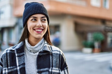 Wall Mural - Young hispanic woman smiling happy standing at the city.