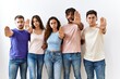 © Krakenimages.com - Group of young people standing together over isolated background doing stop sing with palm of the hand. warning expression with negative and serious gesture on the face.