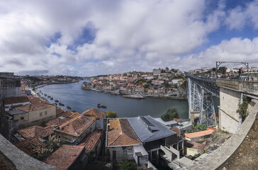 Poster - Scenic view of a river and Luis I Bridge in Porto, Portugal on a cloudy sky background