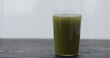 green matcha drink in tumbler glass on black oak table with copy space