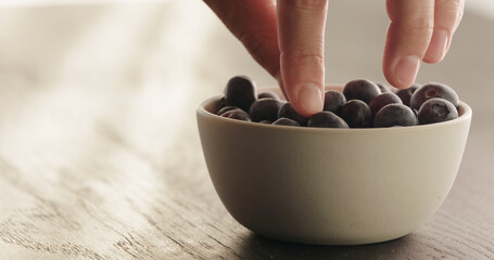 Wall Mural - take blueberries from white bowl on oak table