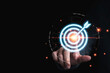 © Dilok - Businessman hand touching to target dart board for setup and achievement objectives target for business investment concept.