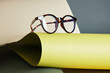 glasses on rolled paper, geometric background, green colors